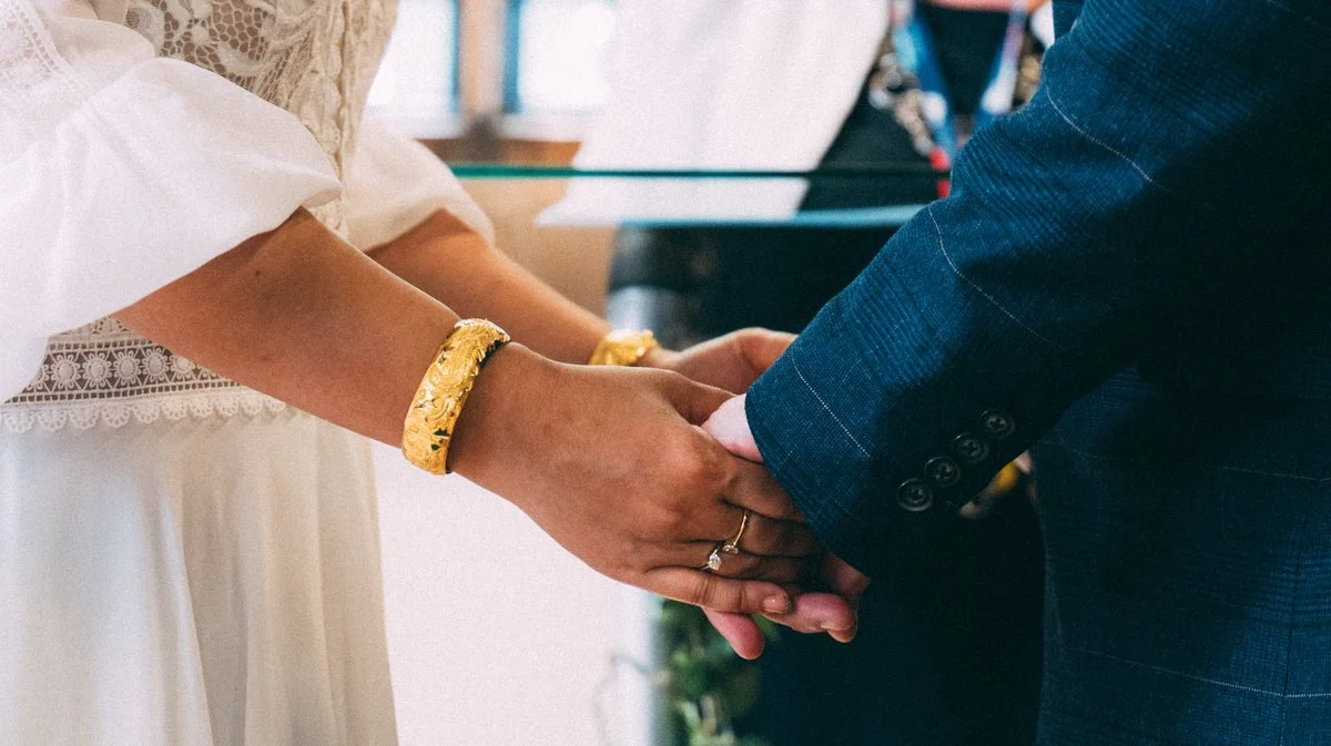 Newlyweds holding hands during their wedding ceremony