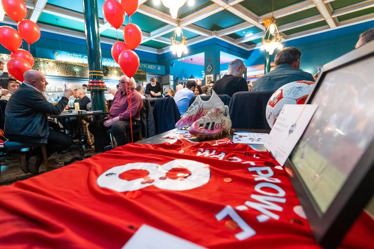 Lively charity sports event with guests, red balloons and fundraising banners